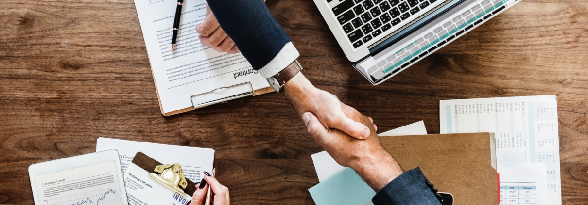 handshake across desk, deal-making